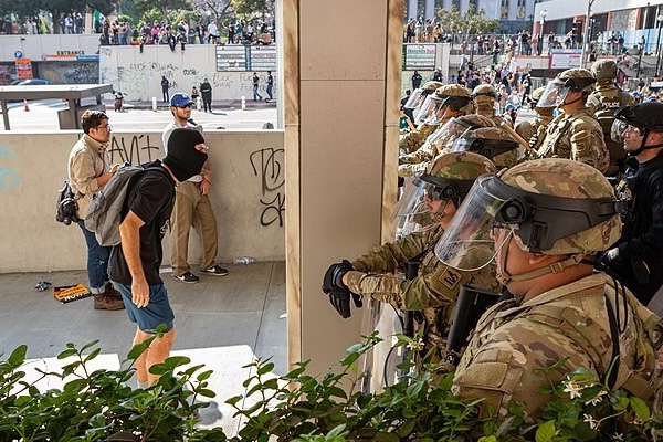 Pictured: Unarmed civilians (left and in background) standing up to the National Guard. Credit Mel Smith