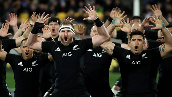 Three professional rugby players before a match with AIG logo on their jerseys